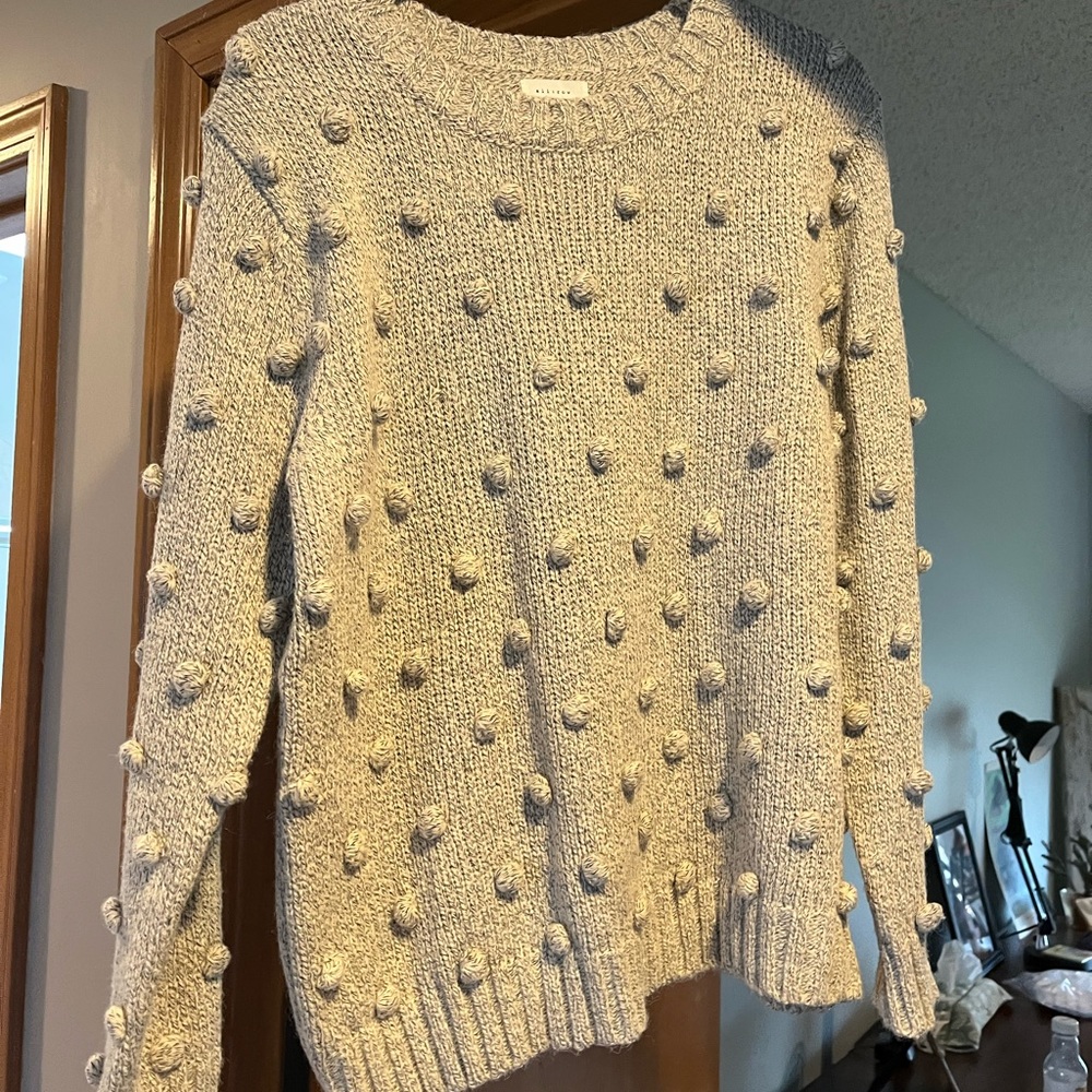 Ladies sweater adorned with ball accents